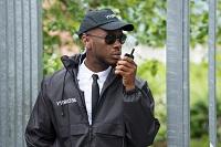 African-American, male security guard talking on radio